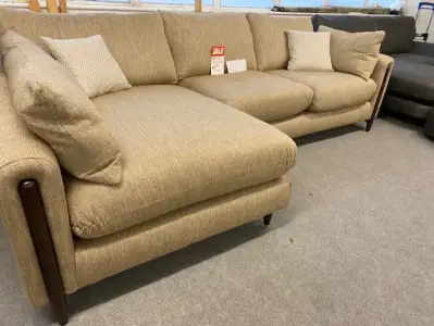 A beige corner sofa with exposed wood frame